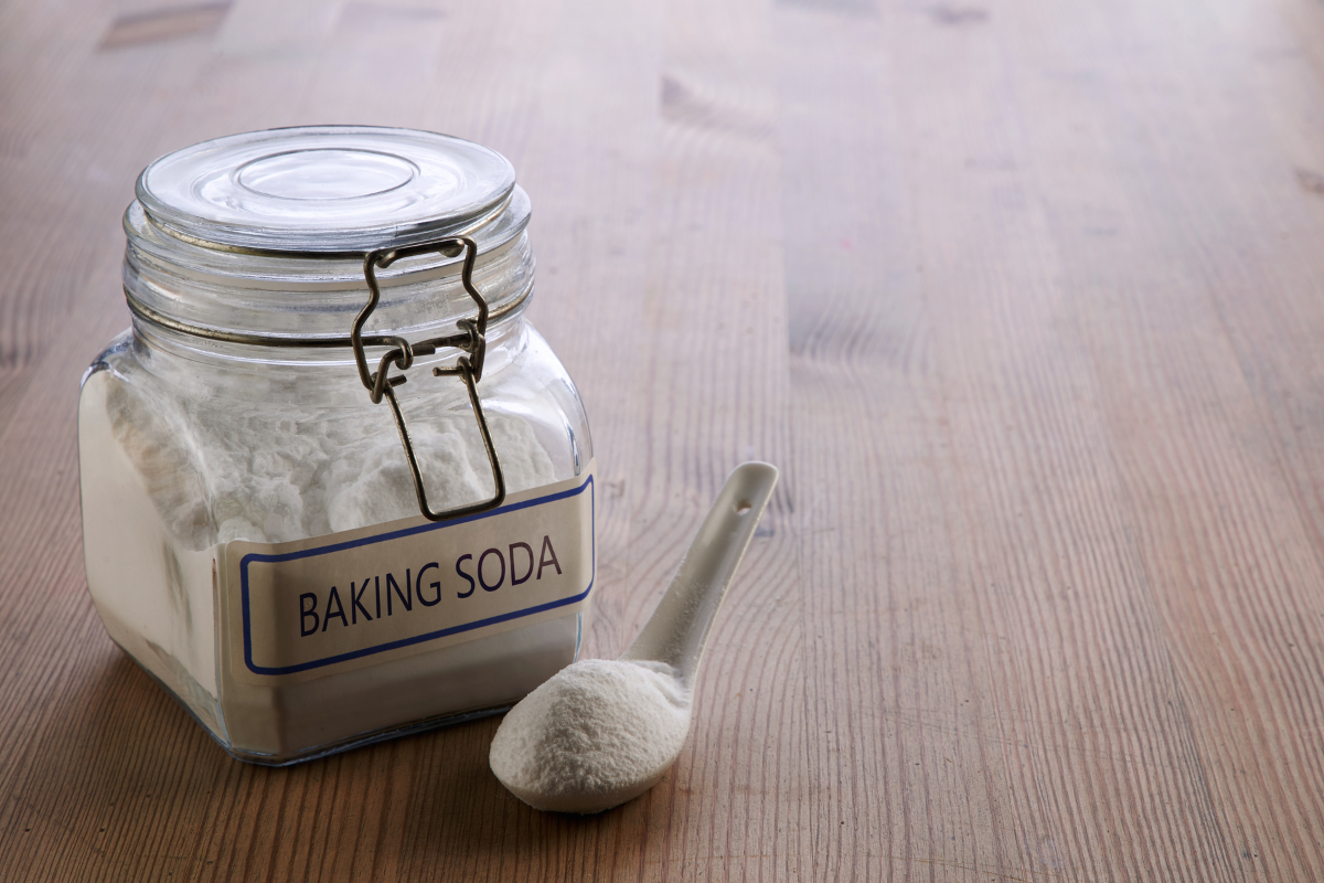 Clarifying shampoo bottle next to baking soda on a bathroom counter