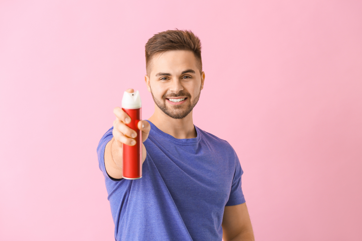 man spraying hair product