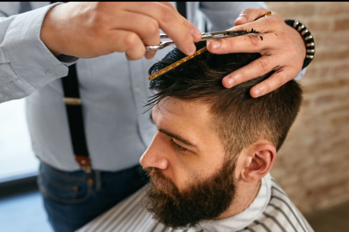 A barber consulting with a male client who has medium-to-long hair
