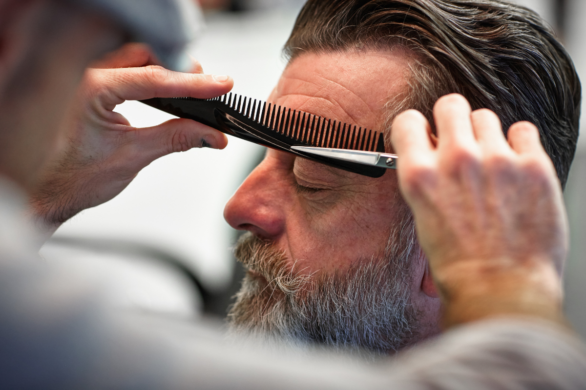 barber trimming man eyebrows