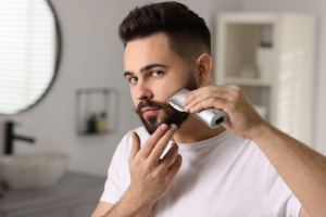 man trimming beard at home