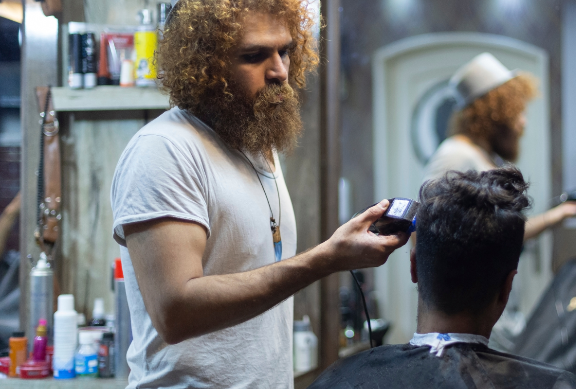 man using clippers on beard