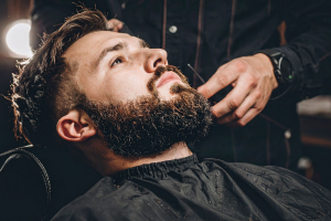 man trimming beard barbershop
