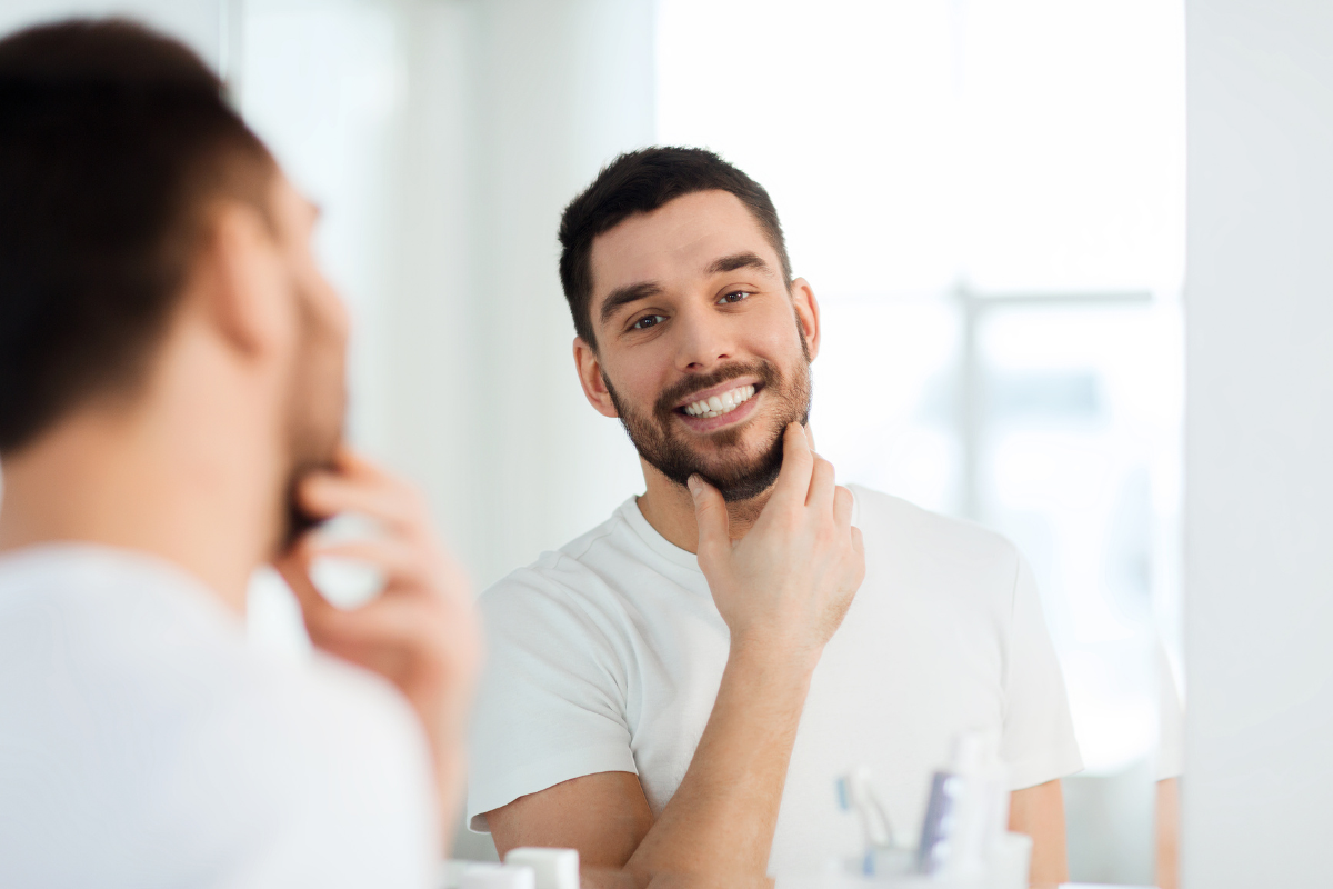 young man growing beard mirror